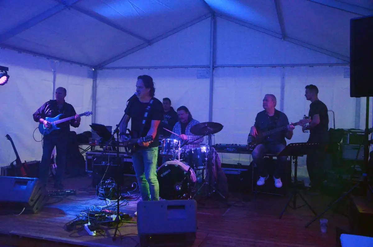 Band rock sotto un tendone illuminato di blu